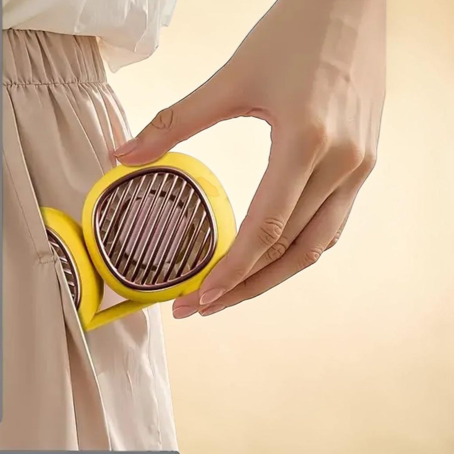 Ventilateur de cou Sereine plié tenant dans une main, format ultra-compact 12 cm